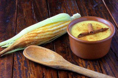 CURAU, Mısır tatlı ve tarçın ile Brezilya mutfağının tipik tatlı krema ahşap masa üzerinde seramik kase yerleştirilir. Uzay kopyalayın. Yakın çekim