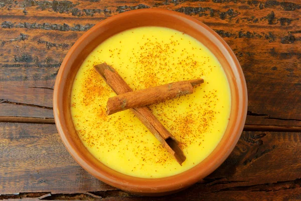 CURAU, Mısır tatlı ve tarçın ile Brezilya mutfağının tipik tatlı krema ahşap masa üzerinde seramik kase yerleştirilir. Üstten görünüm. Yakın çekim