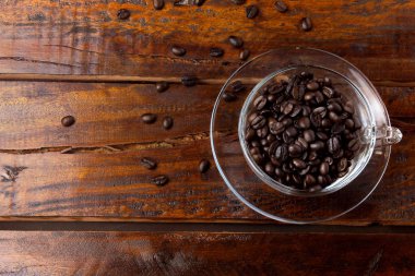 bir fincan kahve kavrulmuş ve taze fasulye rustik ahşap masa ile izole. Üst ve yakından görmek