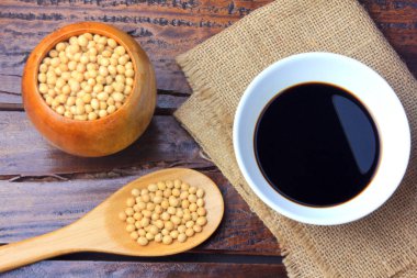 Soya fasulyesi rustik ahşap masa üzerinde seramik bir kasede koyu soya sosu ile