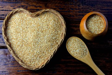 Susam rustik ahşap masa, üstten görünüm izole kalp şeklinde sepet içinde.