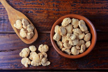 Soya fasulyesi et, kahverengi bir seramik kase parçaları. Rustik ahşap arka plan üzerinde ham soya fasulyesi parçaları Üstten Görünüm