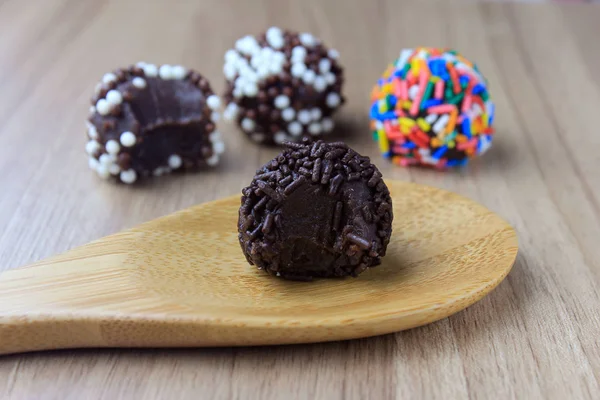 Brigadeiro (Brigadier), süße Schokolade, typisch für die brasilianische Küche, mit Partikeln überzogen, vor einem hölzernen Hintergrund. — Stockfoto