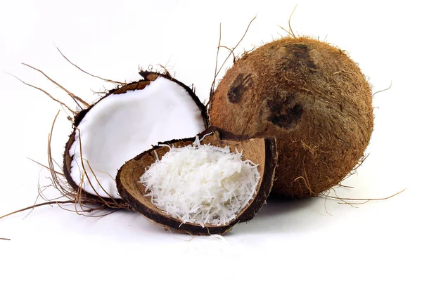 Свежие хлопья кокоса помещены в коре и оболочке изолированы на белом фоне — стоковое фото