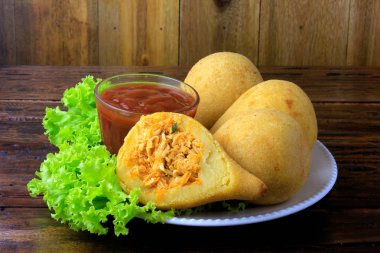 Coxinha çanak, geleneksel Brezilya mutfağı atıştırmalıklar tavuk ile doldurulmuş, rustik ahşap masa üzerinde