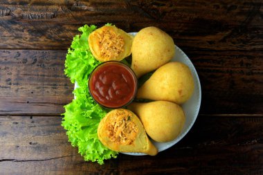 Coxinha çanak, geleneksel Brezilya mutfağı atıştırmalıklar tavuk ile doldurulmuş, rustik ahşap masa üzerinde