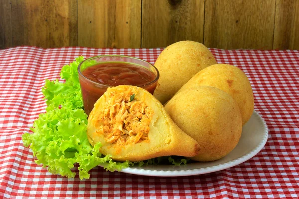 Coxinha în farfurie, gustări tradiționale din bucătăria braziliană umplute cu pui, pe masă rustică din lemn — Fotografie, imagine de stoc