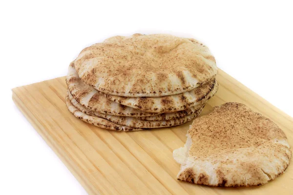 Пита хлеб изолирован на белом фоне в деревянной лопатке. Традиционные блюда арабской кухни — стоковое фото