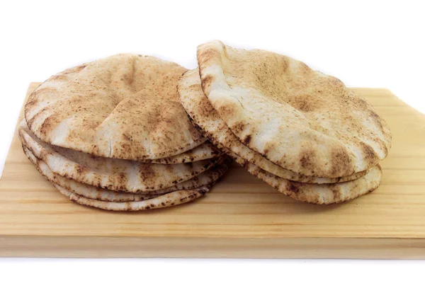 木のスパチュラで白い背景に分離されたピタパン。アラビア料理の伝統料理 — ストック写真