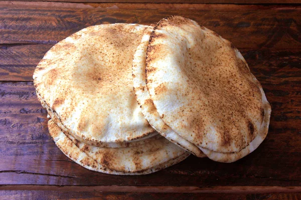 Пита хлеб изолирован на деревенской деревянной столе.Традиционные блюда арабской кухни — стоковое фото