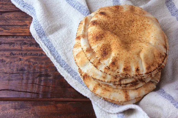 Fladenbrot isoliert auf rustikalem Holztisch auf rustikalem Tuch. traditionelle Speisen der arabischen Küche — Stockfoto
