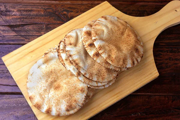 오븐에서 나오는 나무 주걱에 고립 된 피타 빵. 아랍 요리의 전통 음식 — 스톡 사진