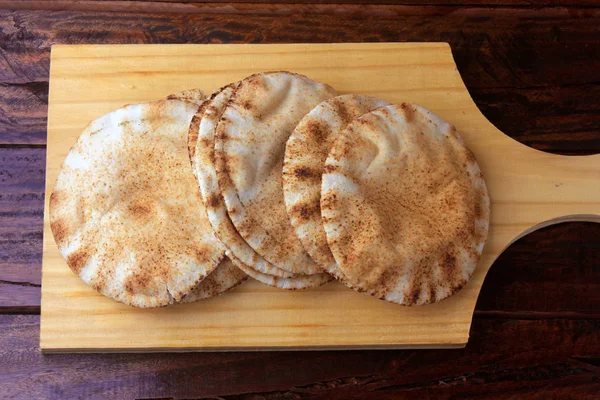 Pita brood geïsoleerd op houten spatel coming out van de oven. Traditionele gerechten uit de Arabische keuken — Stockfoto