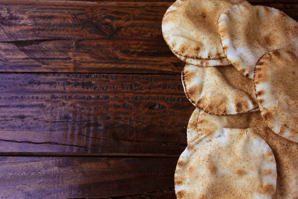 Fladenbrot isoliert auf rustikalem Holztisch. Traditionelle Speisen der arabischen Küche — Stockfoto