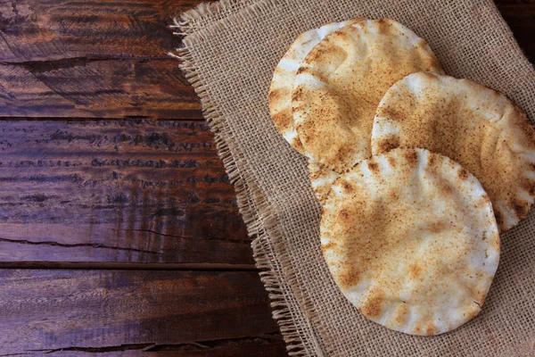 Fladenbrot isoliert auf rustikalem Holztisch auf rustikalem Tuch. traditionelle Speisen der arabischen Küche — Stockfoto