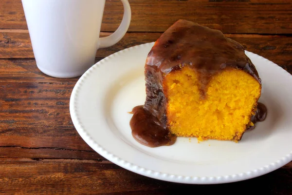 Rebanada de pastel de zanahoria con recubrimiento de chocolate en plato de cerámica blanca en mesa de madera rústica — Foto de Stock