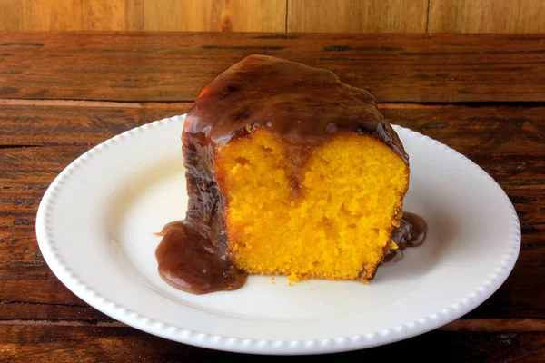 Tranche de gâteau aux carottes avec revêtement chocolat sur plaque de céramique blanche sur table en bois rustique — Photo