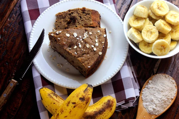 Domácí banánový dort vyrobený z ovesné kaše na rustikálním dřevěném stole. bez cukru, bez mléka, bez lepku — Stock fotografie