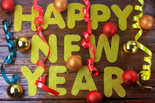 Feliz año nuevo cartel de celebración, mensaje de bienvenida con adornos sobre fondo de madera —  Fotos de Stock