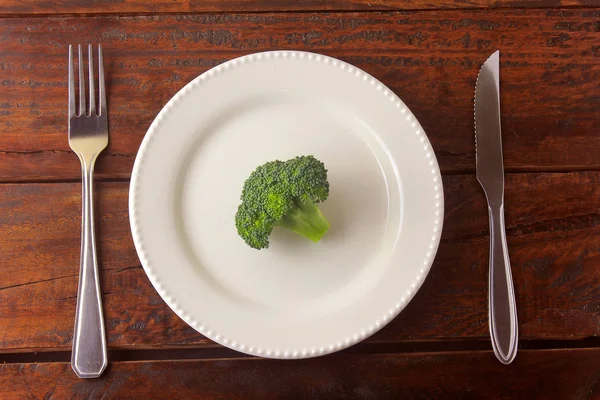 Begrip calorie beperking. Streng dieet. Gesneden pod geïsoleerd op witte plaat met vork en mes — Stockfoto