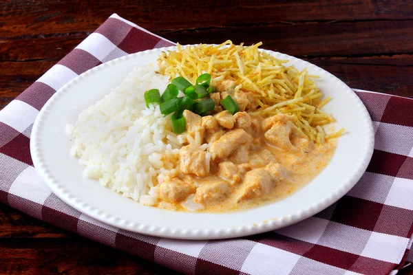 Kurczak Stroganoff, to danie pochodzące z kuchni rosyjskiej, że w Brazylii składa się z kwaśnej śmietany z ekstraktu pomidorowego, ryż i chipsy ziemniaczane. — Zdjęcie stockowe