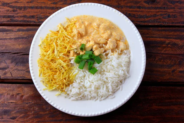 Chicken stroganoff, is a dish originating from Russian cuisine that in Brazil is composed of sour cream with tomato extract, rice and potato chips. — Stock Photo, Image