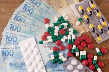 İlaçlar, kapsüller, haplar ve ilaveler Brezilya para biriminin yanında. Yüksek uyuşturucu fiyatları kavramı