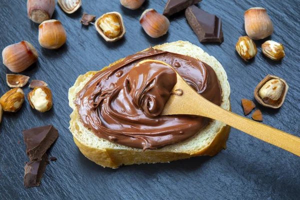 Rebanada Pan Con Crema Chocolate Avellanas Mesa Negra Servir Delicioso —  Fotos de Stock