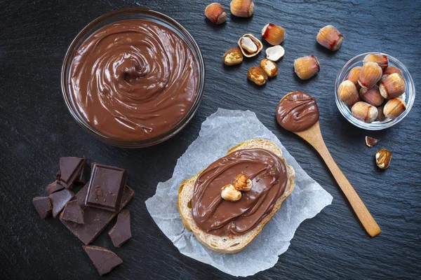 Rebanada Pan Con Crema Chocolate Avellanas Mesa Negra Servir Delicioso —  Fotos de Stock