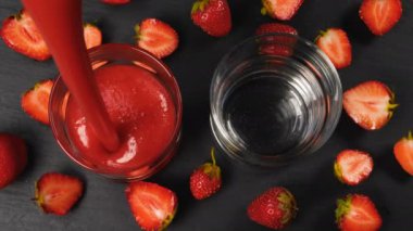 Taze çilek güler yüzlü gözlük içmek için hazır akan. Sağlıklı içme kavramı. 4k