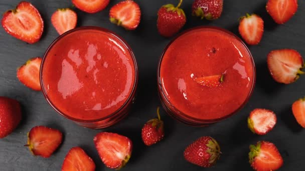 イチゴは スローモーションで新鮮なスムージーに落下します 健康的な飲酒のコンセプト — ストック動画