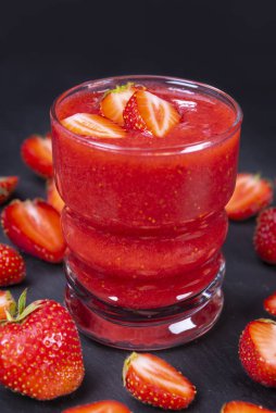 Çilek taze yüzlü siyah tablo içinde. Sağlıklı içme kavramı. Çilek cam ile güler yüzlü odaklanmak.