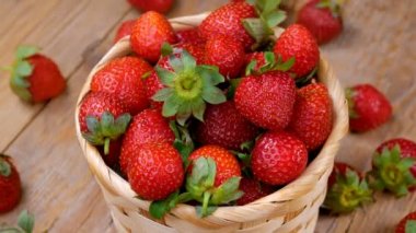 Taze çilek sepeti ahşap masanın üstüne iplik. Sağlıklı beslenme kavramı. Taze meyve arka plan. 4k