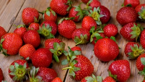frische Erdbeeren, die sich auf einem Holztisch drehen. Konzept für gesunde Ernährung. frische Früchte Hintergrund. 4k
