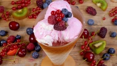 Orman meyve dondurma Kupası tahta masada yazında tam döndürme meyve çilek. 4k