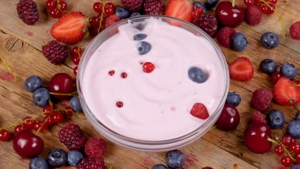 在酸奶中掉落的森林水果 健康早餐概念与酸奶和果子在转动的桌 — 图库视频影像