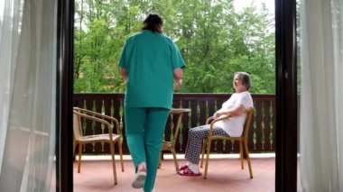 Gülümseyen genç hemşire Hemşirelik evde mutlu kadın kıdemli için kahvaltı servisi Pan. Yavaş hareket 4k