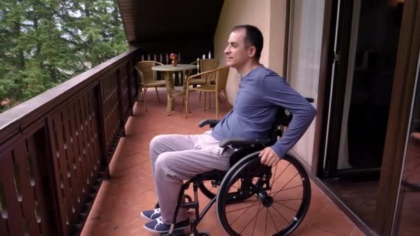 Lächelnder Junger Mann Rollstuhl Entspannt Auf Der Terrasse Zeitlupe Handbewegung — Stockvideo