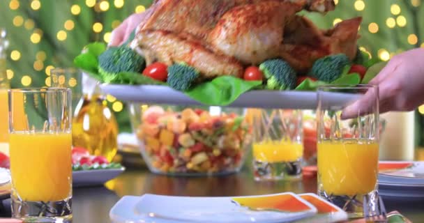 女性の手は ロースト七面鳥をお祝いのテーブルのクローズアップに野菜で飾った ディナーのためのロースト七面鳥と感謝祭を祝う ドリーショット4K — ストック動画