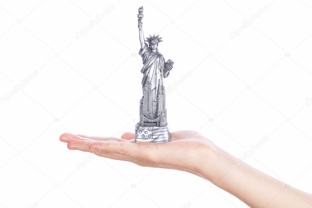 Hand holding a Statue of Liberty souvenir toy
