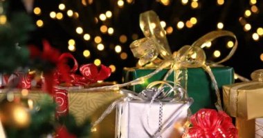Noel ağacının yanında Noel hediyeleri. Atmosferik ışıklarda Noel hediyeleri. Dolly 4k atış