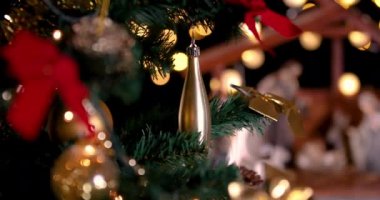 Noel ağacıyakınında atmosferik ışıklar ile İsa Mesih Nativity sahne. Noel sahnesi. Odak Noel ağacından yemlik hareket ediyor. Dolly 4k atış