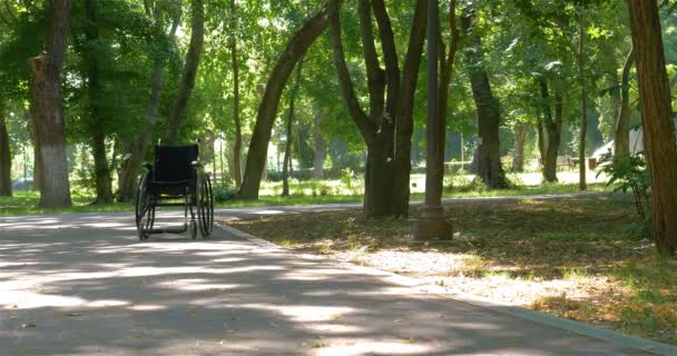 Fauteuil roulant laissé vide à l'extérieur dans le parc en été. 4k