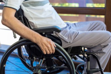 Evde ya da ofiste tekerlekli sandalyedeki adam. Eline odaklan..