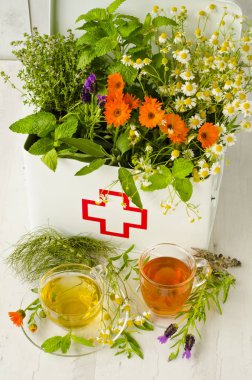 Alternatif Tıp. Biberiye, nane, papatya, kekik, melissa, lavanta ve ilk yardım kutusunda calendula. Ön planda bitkisel infüzyon.