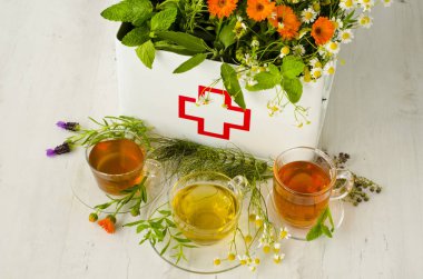 Alternatif Tıp. Biberiye, nane, papatya, kekik, melissa, lavanta ve ilk yardım kutusunda calendula. Ön planda bitkisel infüzyon.