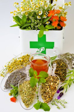 Alternatif Tıp. Biberiye, nane, papatya, kekik, melissa, lavanta ve ilk yardım kutusunda calendula. Kuru otlar ve ön planda bitkisel infüzyon.