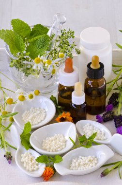 Alternatif Tıp. Homeopati. Globülleri, uçucu yağlar ve beyaz arka plan üzerinde taze otlar.