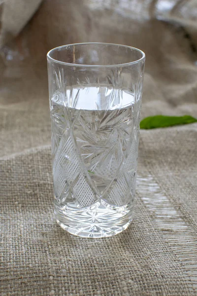 keten masa örtüsü üzerinde kristal bardak su