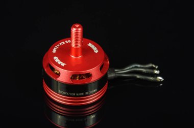 Small brushless motor for racing drones on the dark background clipart